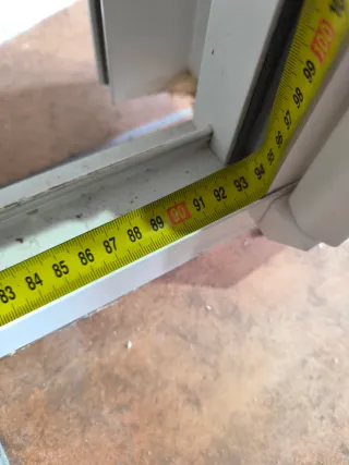 Ventana de aluminio blanco con persiana.