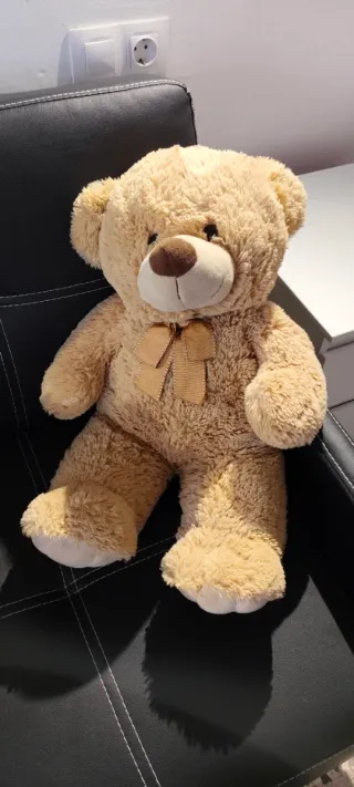 Oso de peluche marrón con lazo