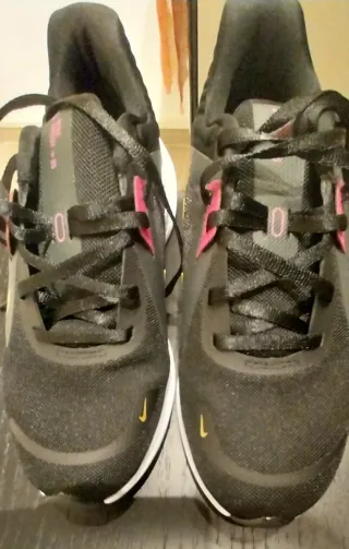 Scarpe sportive Nike nere e baffo dorato