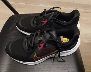 Scarpe sportive Nike nere e baffo dorato