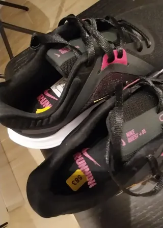 Scarpe sportive Nike nere e baffo dorato