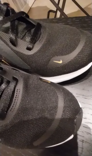 Scarpe sportive Nike nere e baffo dorato