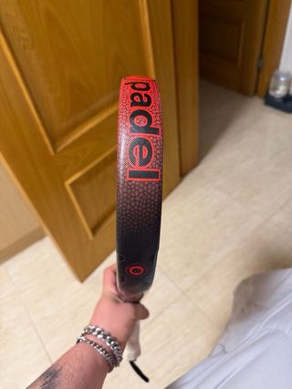 Pala de pádel roja con puntos negros