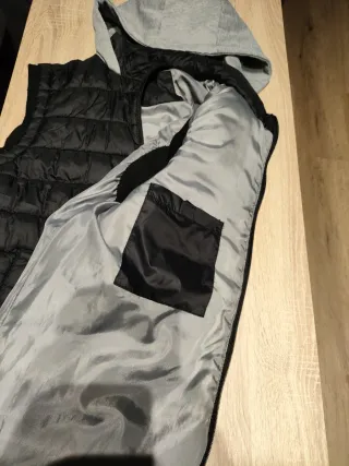 Chaleco negro con capucha gris