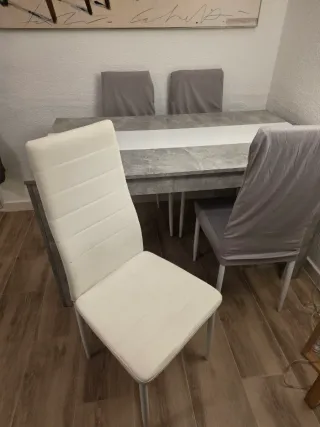 Mesa comedor gris con 4 sillas y fundas