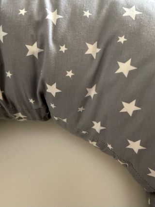 Cojín de lactancia gris con estrellas