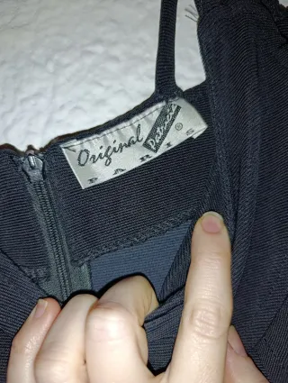 Vestido fiesta negro ajustado con adornos dorados.