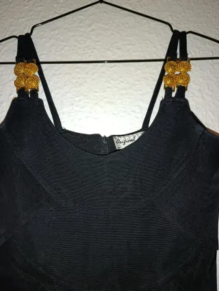 Vestido fiesta negro ajustado con adornos dorados.