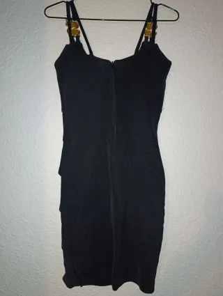 Vestido fiesta negro ajustado con adornos dorados.