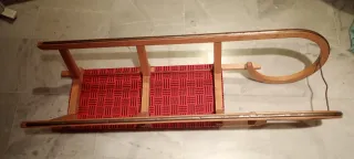 Trineo de madera con asiento rojo