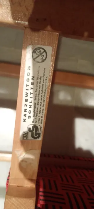 Trineo de madera con asiento rojo