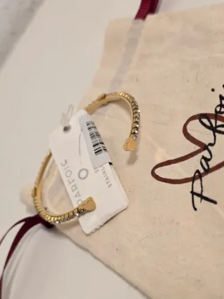 Pulsera abierta dorada con corazones