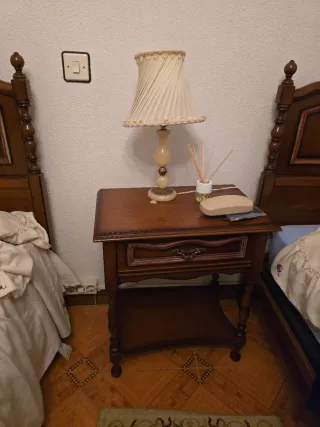 Camas de madera con colcha y mesita