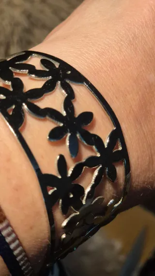 Pulsera plateada con diseño de flores