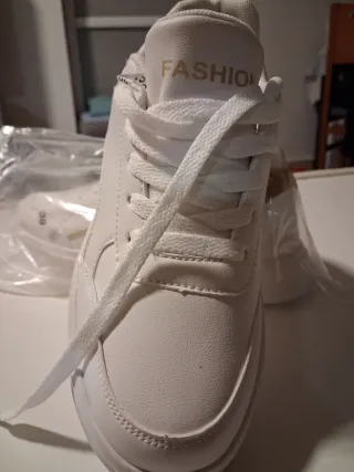 Zapatillas deportivas blancas y doradas