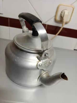 Cafetera antigua de aluminio con tapadera.