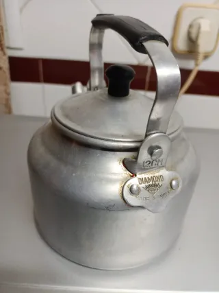 Cafetera antigua de aluminio con tapadera.