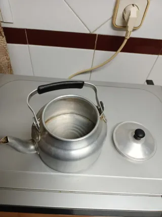 Cafetera antigua de aluminio con tapadera.