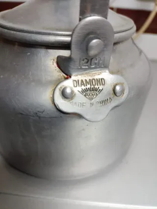 Cafetera antigua de aluminio con tapadera.