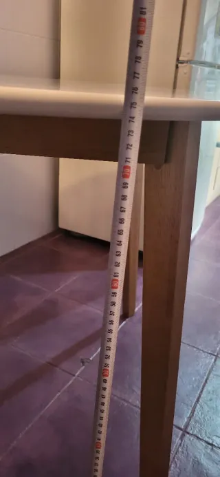 Mesa redonda blanca con 4 sillas negras de plástic