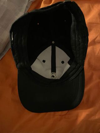 Gorra negra con logo de sol y olas