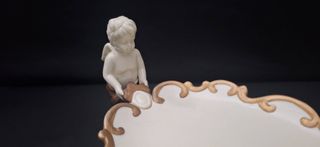 Antiguo centro de mesa de porcelana con querubines
