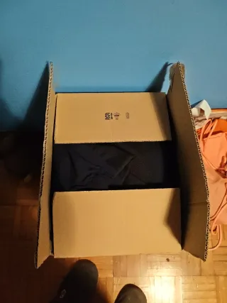 Ropa de nieve roja y caja con ropa térmica