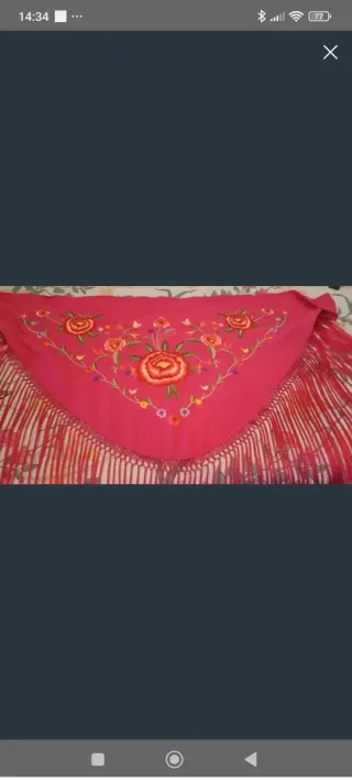Traje de flamenca azul con volantes y mantoncillo.