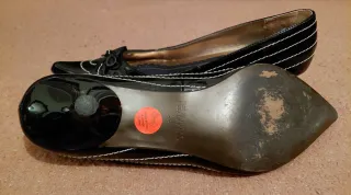 Zapatos charol negro con pespunte en blanco.