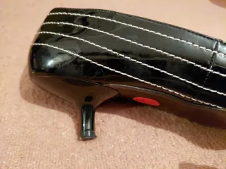 Zapatos charol negro con pespunte en blanco.