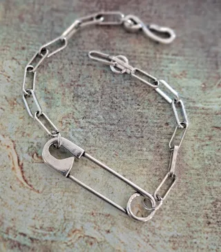 Pulsera de plata con diseño de imperdible.