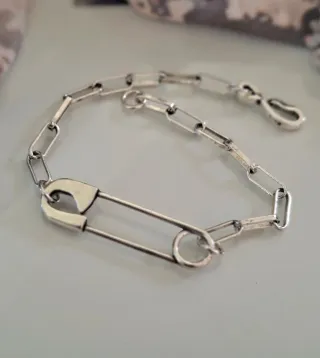 Pulsera de plata con diseño de imperdible.