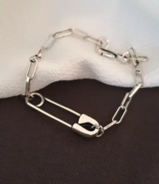 Pulsera de plata con diseño de imperdible.
