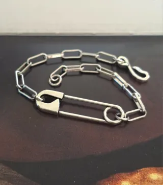 Pulsera de plata con diseño de imperdible.