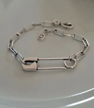 Pulsera de plata con diseño de imperdible.