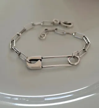 Pulsera de plata con diseño de imperdible.