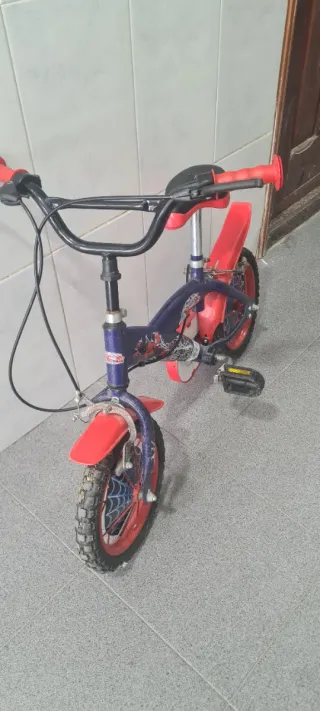 Bicicleta infantil roja y azul en buen estado