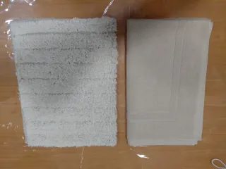 Dos Alfombras de baño beige.