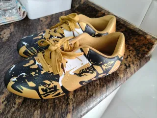 Zapatillas de fútbol doradas y negras