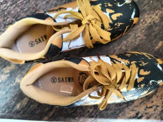 Zapatillas de fútbol doradas y negras