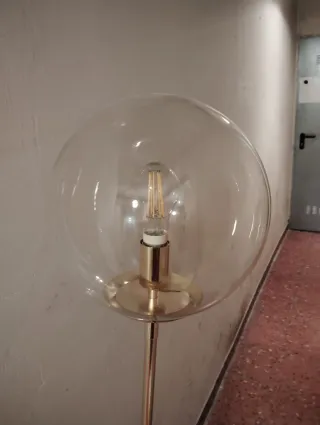 Lámpara de pie dorada y transparente