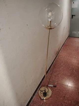 Lámpara de pie dorada y transparente