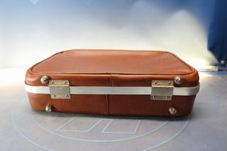 Pequeña maleta vintage en cuero marrón.