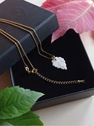 Colgante de cerámica y oro con forma de hoja.