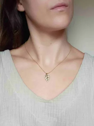 Colgante de cerámica y oro con forma de hoja.