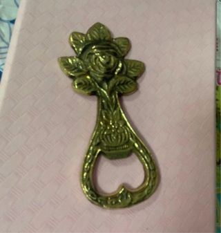 Abridor de latón antiguo con diseño de rosa