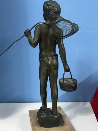 Statua ragazzo con rete da pesca e secchio