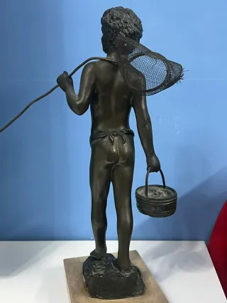 Statua ragazzo con rete da pesca e secchio