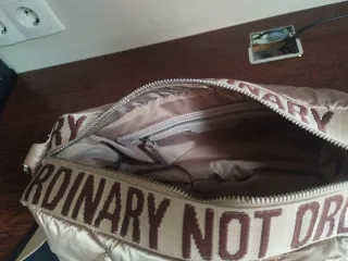 Bolso acolchado beige con texto