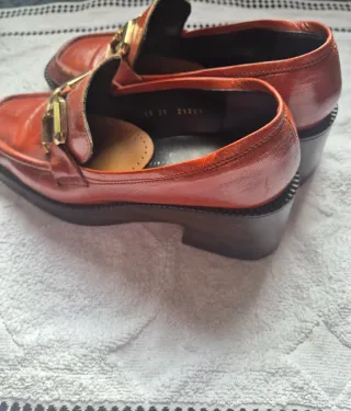 Mocasines rojos con hebilla dorada